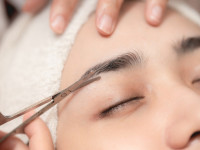 Woman having eyebrow slit in a salon